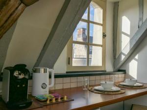 un comptoir de cuisine avec une cafetière et une fenêtre dans l'établissement Suite Toussaint - Calme & Authentique, à Angers