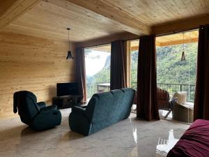 Country Homes في إيلا: غرفة معيشة بها أريكة وكراسي ونافذة كبيرة