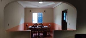 una sala da pranzo con tavolo, sedie e finestra di Live with the locals in Bamboo House a Tanji