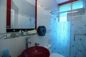 La salle de bains est pourvue d'une douche et de toilettes rouges. dans l'établissement Khách Sạn Huỳnh Anh, à Hô-Chi-Minh-Ville