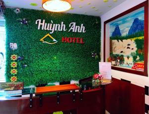 un mur vert avec un panneau d'hôtel dans l'établissement Khách Sạn Huỳnh Anh, à Hô-Chi-Minh-Ville
