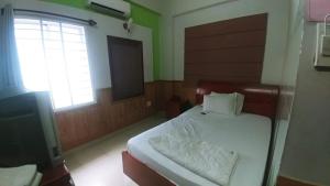 - une chambre avec un lit et une télévision dans l'établissement Khách Sạn Huỳnh Anh, à Hô-Chi-Minh-Ville
