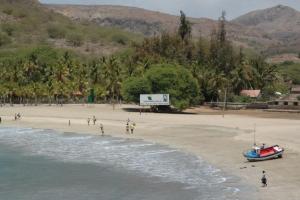 a group of people on a beach with a boat at Family villa: pool and panoramic view in Praia