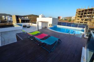 a couple of chairs sitting on a roof at Family villa: pool and panoramic view in Praia