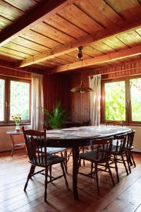 un comedor con una gran mesa de madera y sillas en Stara Leśniczówka, en Godkowo