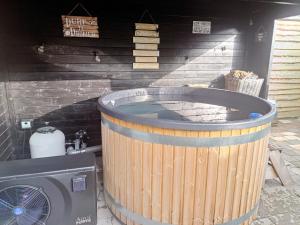 a large wooden tub in a room with a washing machine at bnbheerhugowaard in Heerhugowaard