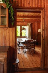 comedor con mesa y sillas en una cabaña en Stara Leśniczówka, en Godkowo
