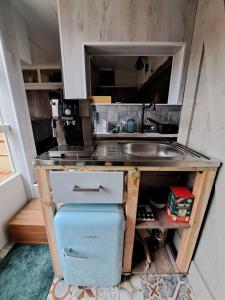 a small kitchen with a sink and a refrigerator at bnbheerhugowaard in Heerhugowaard