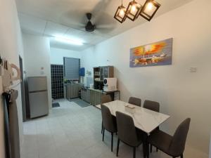 a kitchen and dining room with a table and chairs at Adempuri Homestay 3 in Jitra