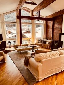 a large living room with couches and tables and windows at Landhaus Frank in Bad Kleinkirchheim