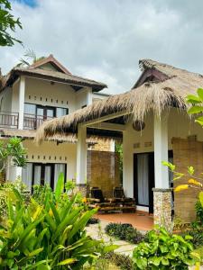 una casa con tetto di paglia di Cewin's Homestay a Kuta Lombok