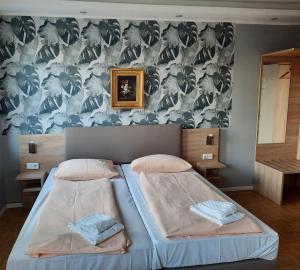 デュッセルドルフにあるホテル レジデンツのベッドルーム1室(ベッド2台付)が備わります。壁紙を用いた内装です。