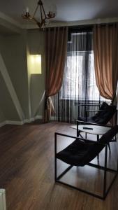 a living room with two beds in front of a window at Deluxe Park Z hotel in Almaty
