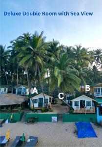a view of a beach with houses and palm trees at The Nest Palolem in Canacona