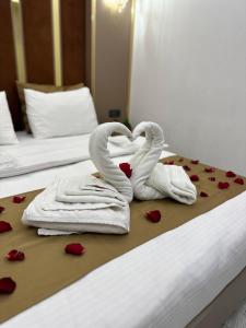 two towels shaped like swans making a heart on a bed at Moonlight Suit Hotel Taksim in Istanbul