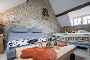 um quarto com 2 camas e uma parede de pedra em Le Moulin de l'étang em Gilles