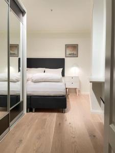 sypialnia z łóżkiem i lustrem w obiekcie Lovely apartment in Tromsø city centre w mieście Tromsø