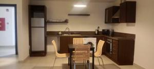 uma cozinha com uma mesa e cadeiras e um lavatório em DeadSea view apartments Samarah Resort E22 em Amã