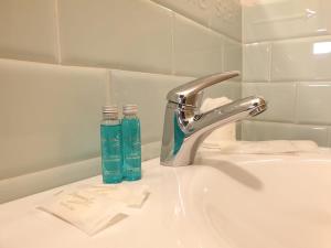 a sink with a faucet and two glass bottles on it at Hotel Aracoeli in Orta San Giulio