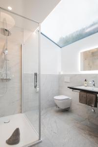 Un baño con ducha, inodoro y lavabo. en BaseCamp Hotel, en Zermatt 37 fotos más