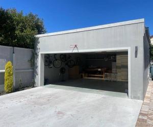 a white garage with a table in it at Charming home, The Vines in Constantia in Cape Town