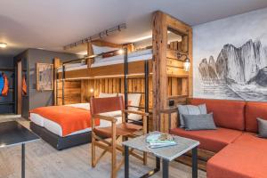 um quarto com um beliche e um sofá em BaseCamp Hotel em Zermatt