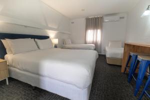 een hotelkamer met een groot wit bed en een bureau bij Caledonian Inn - The Stump in Port Fairy