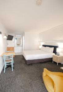 - une chambre avec un lit, une table et une chaise dans l'établissement Caledonian Inn - The Stump, à Port Fairy