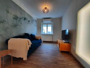 uma sala de estar com um sofá azul e uma televisão em Diana's Stube em Krefeld