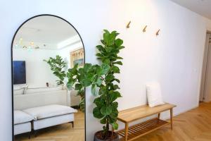 un soggiorno con specchio e pianta di Ultra Luxury 3BR Beach Apartment a Tel Aviv