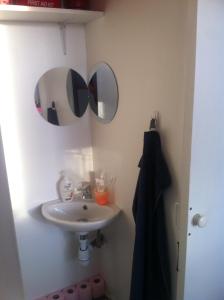 La salle de bains est pourvue d'un lavabo et de deux miroirs. dans l'établissement La Pause Bien-être face Pyrénées, à Livron