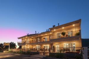 a building with tables and chairs in front of it at 4 Seasons Villas in Plataria