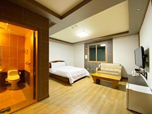 a hotel room with a bed and a television at F1 Hotel in Mokpo