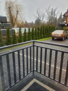 a balcony with a car parked on a street at Apartamenty Majer Łeba in Łeba