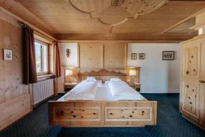 a bedroom with a large bed with a wooden ceiling at Hotel Pradell in Ortisei