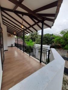 a balcony of a house with a wooden floor at Villa Sunset Tides in Weligama