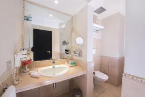 a bathroom with a sink and a toilet and a mirror at Sentido Reef Oasis Aqua Park Resort in Sharm El Sheikh