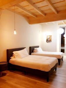 two beds in a room with wooden ceilings at Hotel Aracoeli in Orta San Giulio