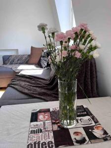 eine Vase mit Blumen auf einem Tisch mit einem Bett in der Unterkunft Central , bright and modern flat up to 4 people in London