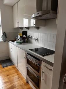 kuchnia z białymi szafkami i piekarnikiem w obiekcie Central , bright and modern flat up to 4 people w Londynie