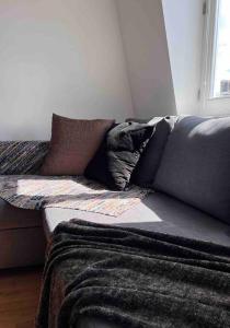 un sofá con almohadas en la sala de estar. en Central , bright and modern flat up to 4 people en Londres