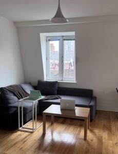 sala de estar con sofá y mesa con 2 ordenadores portátiles en Central , bright and modern flat up to 4 people en Londres