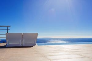 a view of a pool with the ocean in the background at Olive and Aloe Villas in Nomikianá