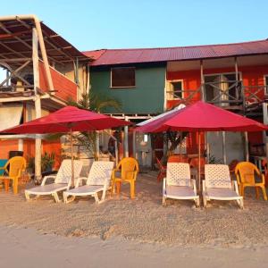 een groep stoelen en parasols op een strand bij Playa Tortuga Cabaña in Playa Blanca