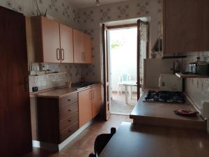 a kitchen with wooden cabinets and a stove top oven at Casa Degli Oleandri Sul Cortile R6314 in Cala Gonone