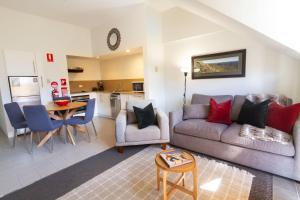 a living room with a couch and a table at Lantern 1 Bedroom Balcony with Panoramic Alpine View in Thredbo