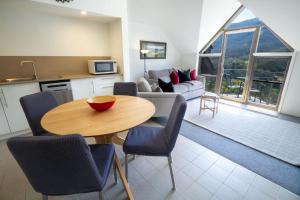 a kitchen and living room with a table and chairs at Lantern 1 Bedroom Balcony with Panoramic Alpine View in Thredbo