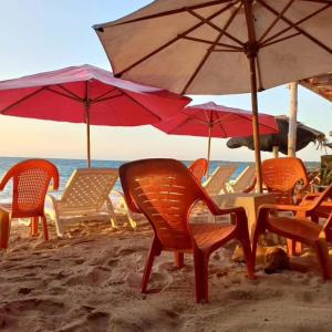 um grupo de cadeiras e guarda-sóis numa praia em Playa Tortuga Cabaña em Playa Blanca