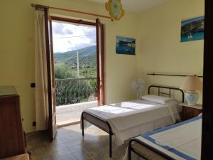 a bedroom with two beds and a large window at Casa Degli Oleandri Sul Cortile R6314 in Cala Gonone