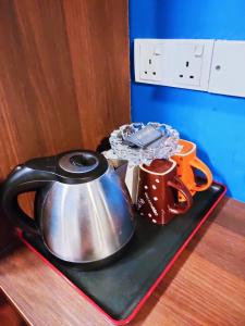 a tea kettle and mugs on a tray on a table at HOTEL YTS in Brinchang